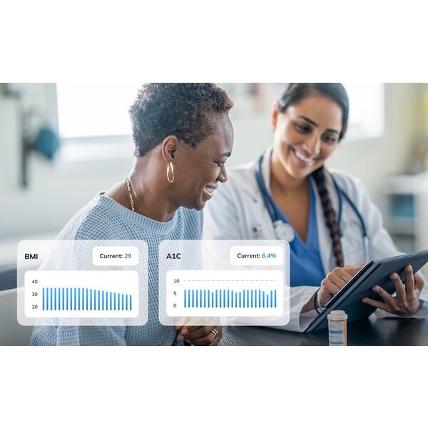 A caring doctor showing results on a tablet to a patient in a hospital gown